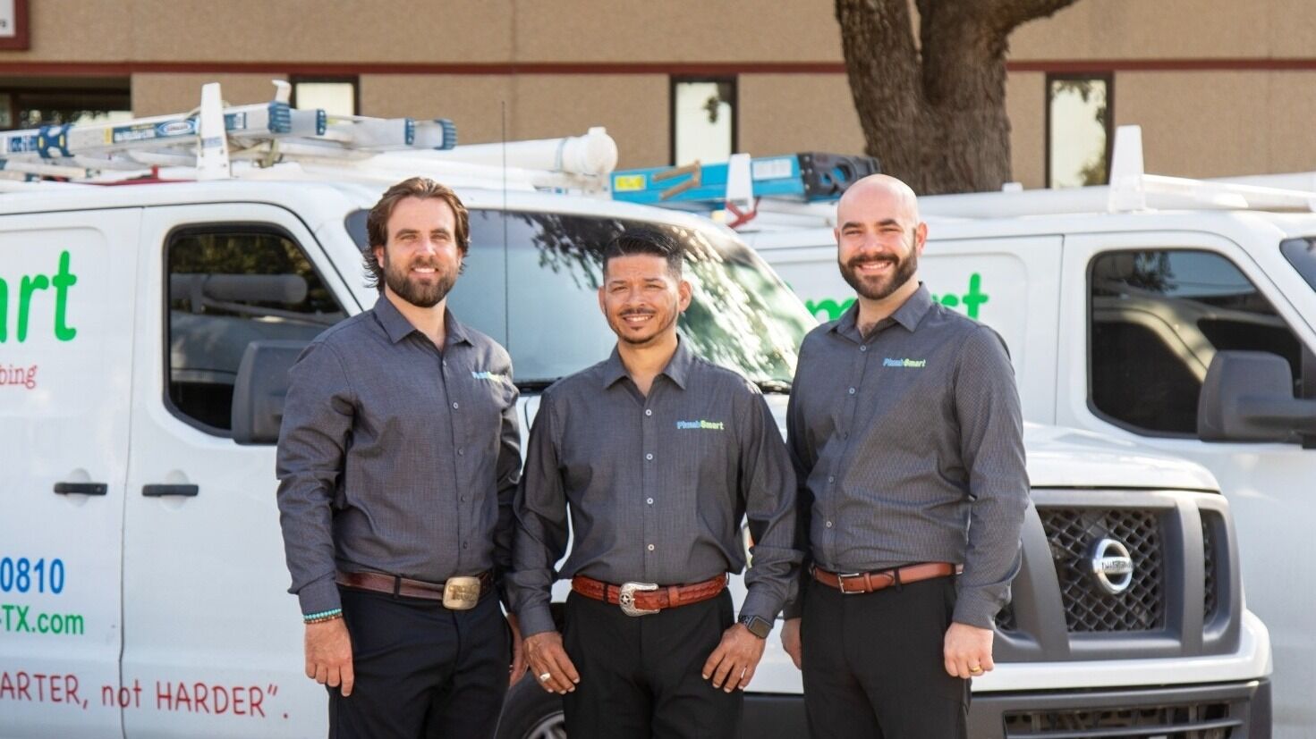 Plumbing team standing in front of service vans